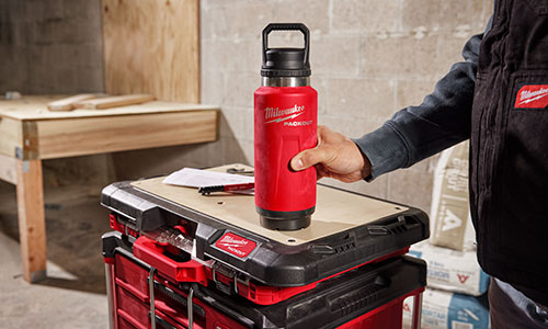 Milwaukee tool box with a man holding a Milwaukee tumbler on top of the tool box
