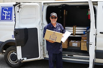 man holding a box standing in front of a delivery truck